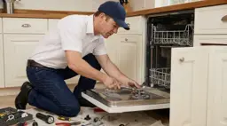 Appliance technician fixing the lower rack area of a dishwasher